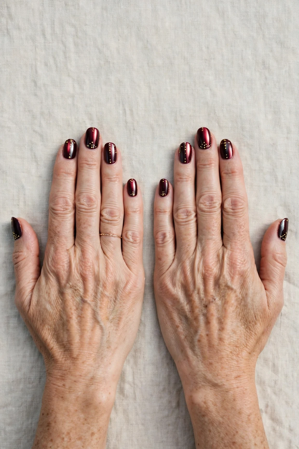 Dark Cherry Velvet Short Nails with a chrome shine and tiny gold dots