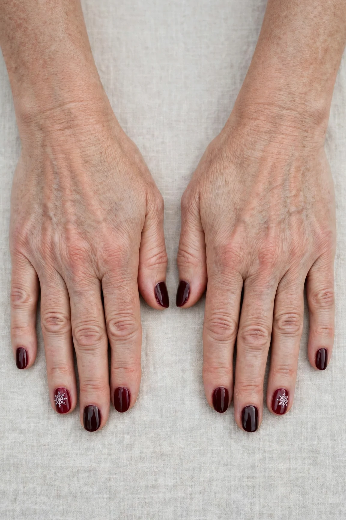 Dark Cherry Velvet Short Nails with a sheer jelly finish and a delicate snowflake on the ring finger