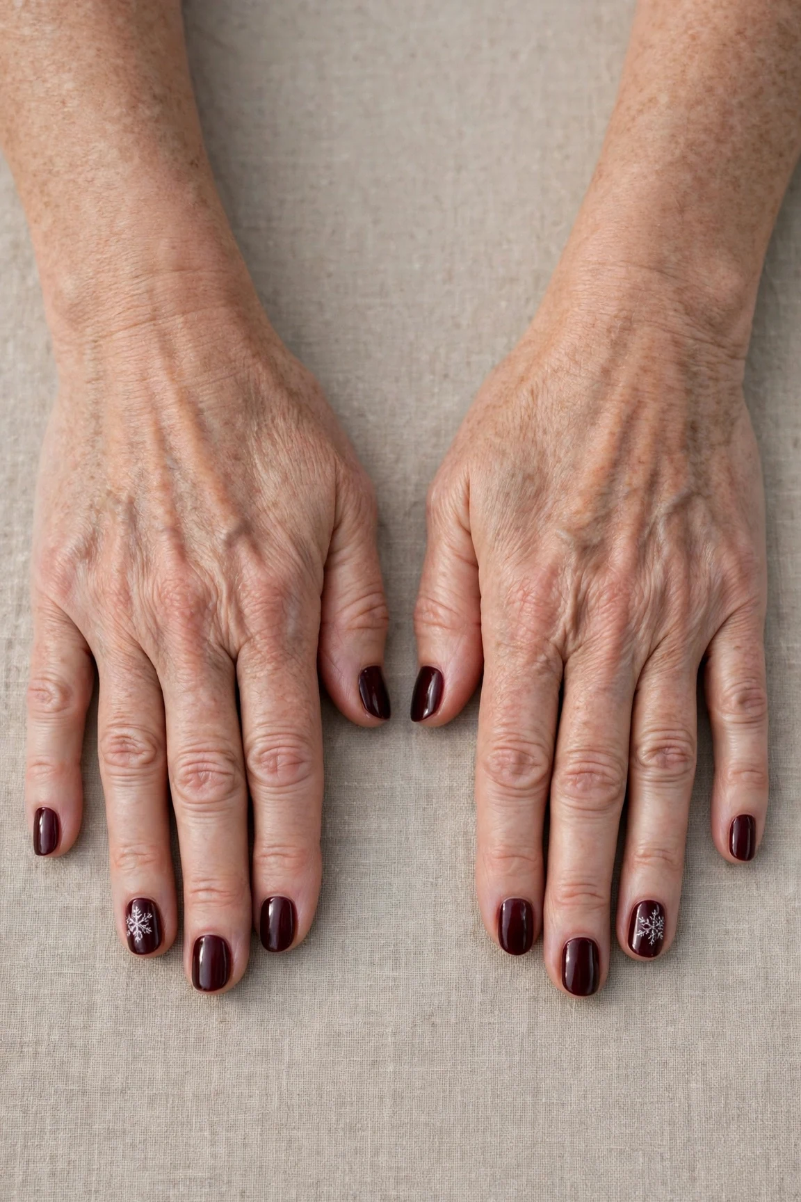 Dark Cherry Velvet Short Nails with a glassy gel finish and a delicate snowflake on the ring finger