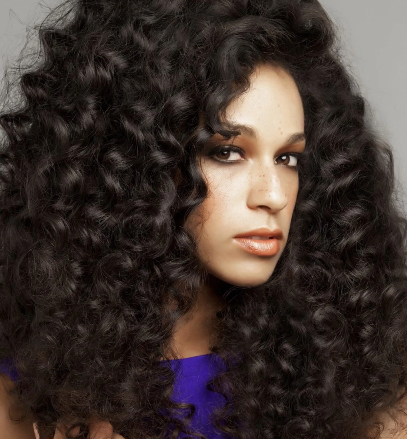 Voluminous Curly Hair with a Deep Side Part and a Side Ponytail