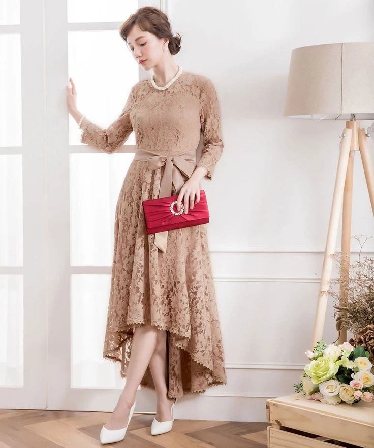 Cream Lace Wrap Dress with a red clutch