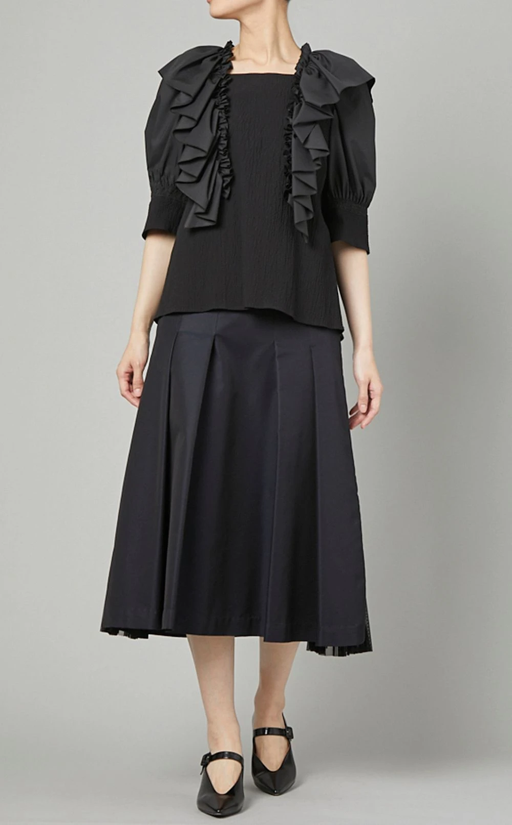 Black Ruffle Blouse and Pleated Skirt with black block-heel pumps