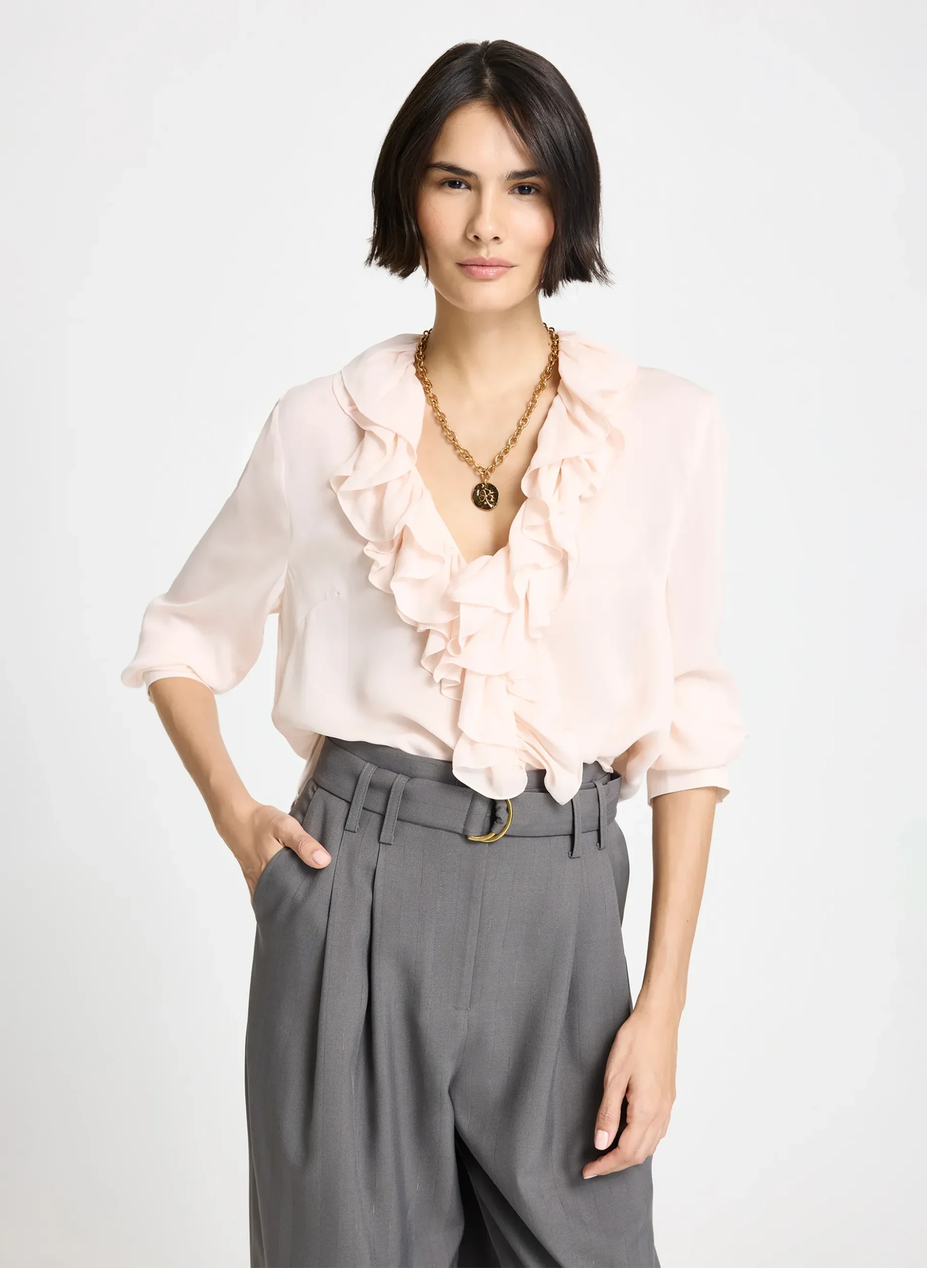 Pink Ruffle Blouse and Wide-Leg Trousers with a gold pendant necklace