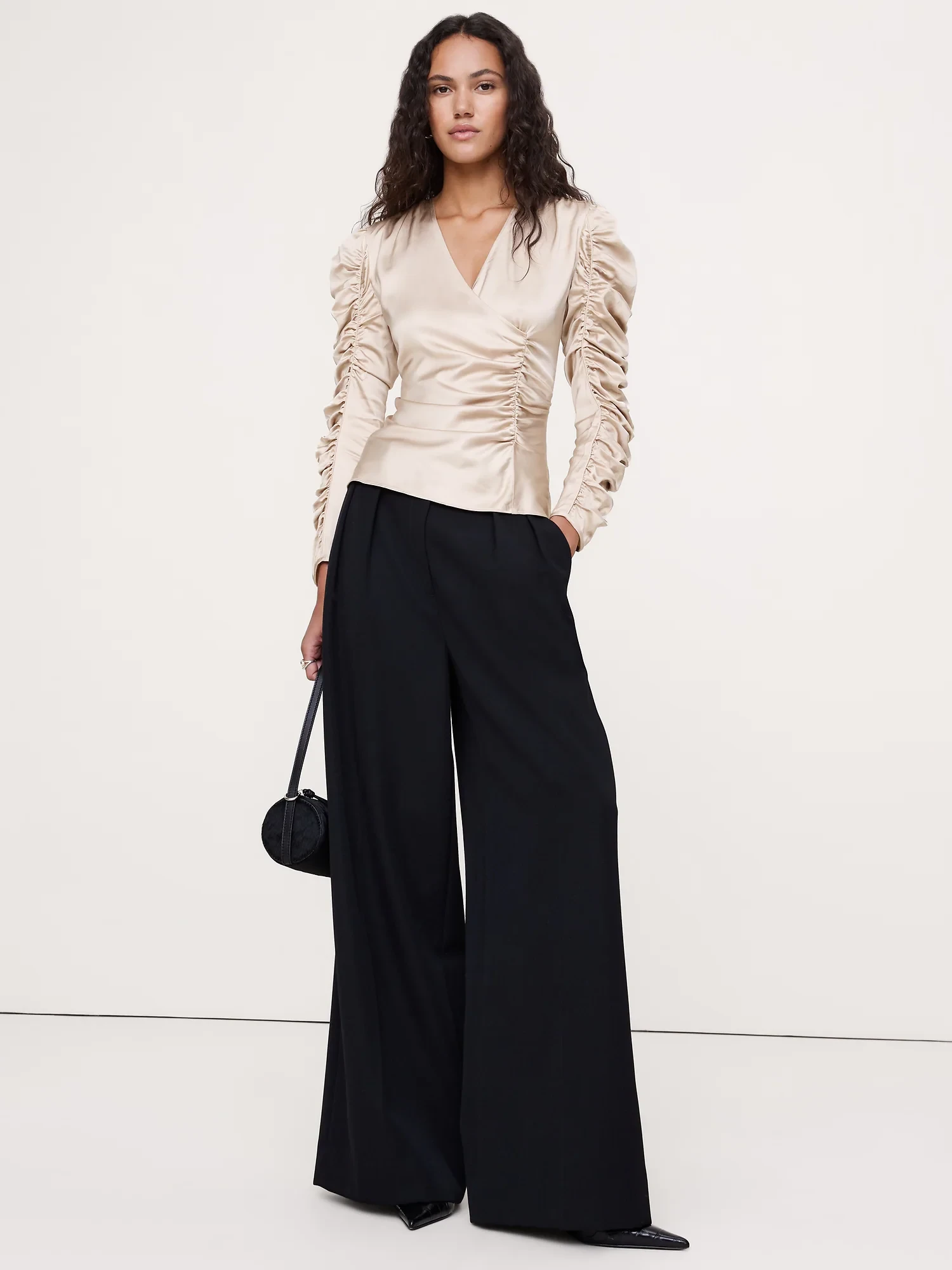 Cream Ruffle Blouse and Trousers with a black satin clutch