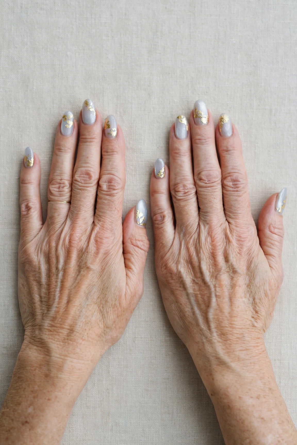Icy Silver Frosted Almond Nails with a sheer jelly finish and gold foil accents