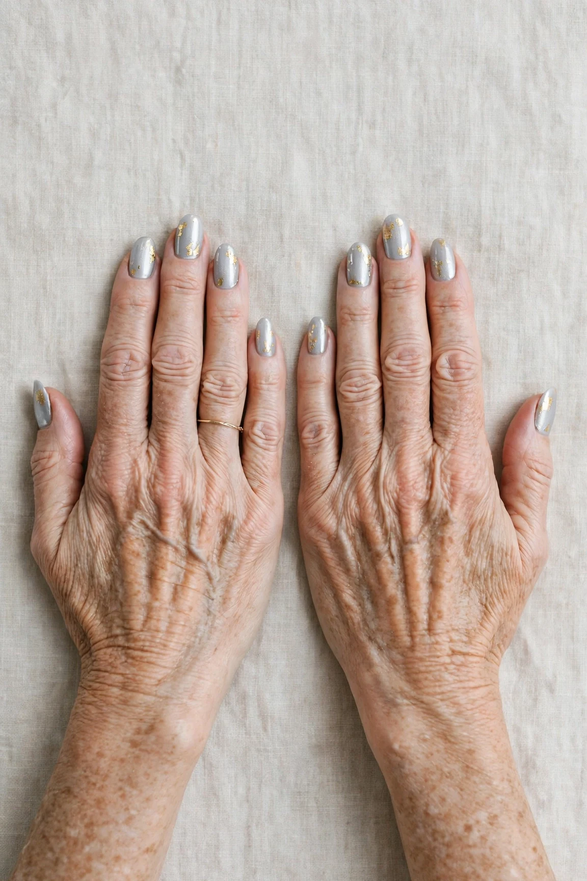 Icy Silver Frosted Almond Nails with a deep glossy shine and gold foil accents