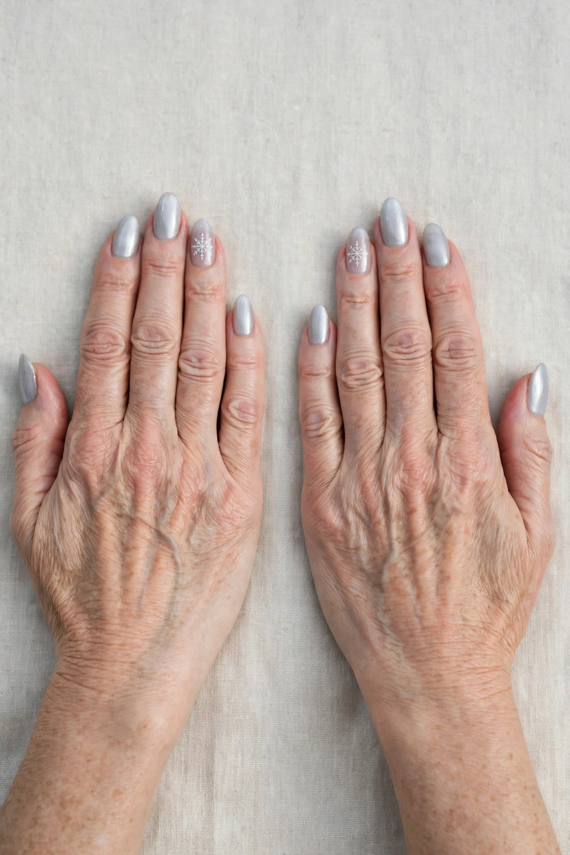 Icy Silver Frosted Almond Nails with a sheer jelly finish and a delicate snowflake on the ring finger