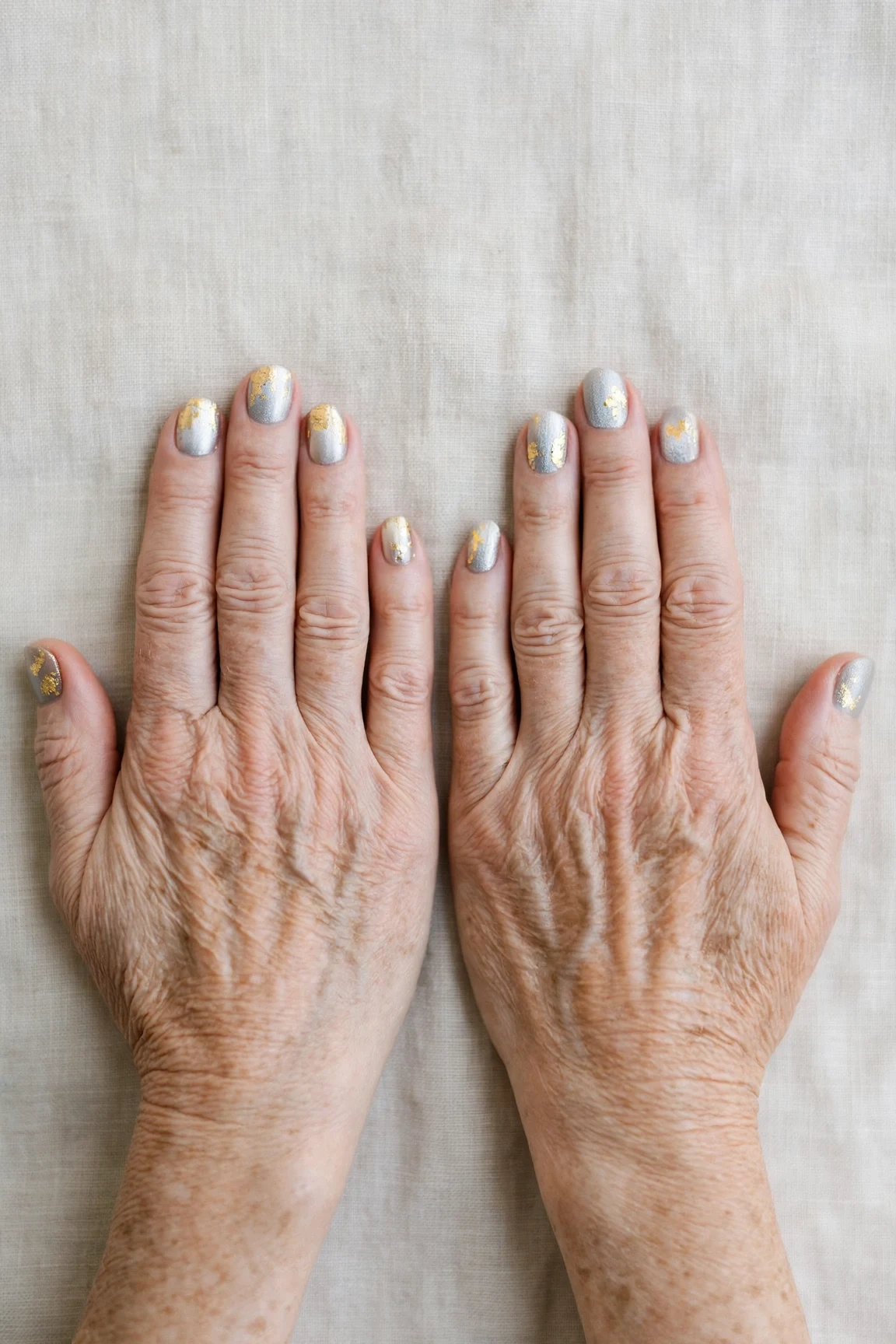 Short Round Icy Silver Frosted Chrome Nails with a frosted shimmer finish and gold foil accents
