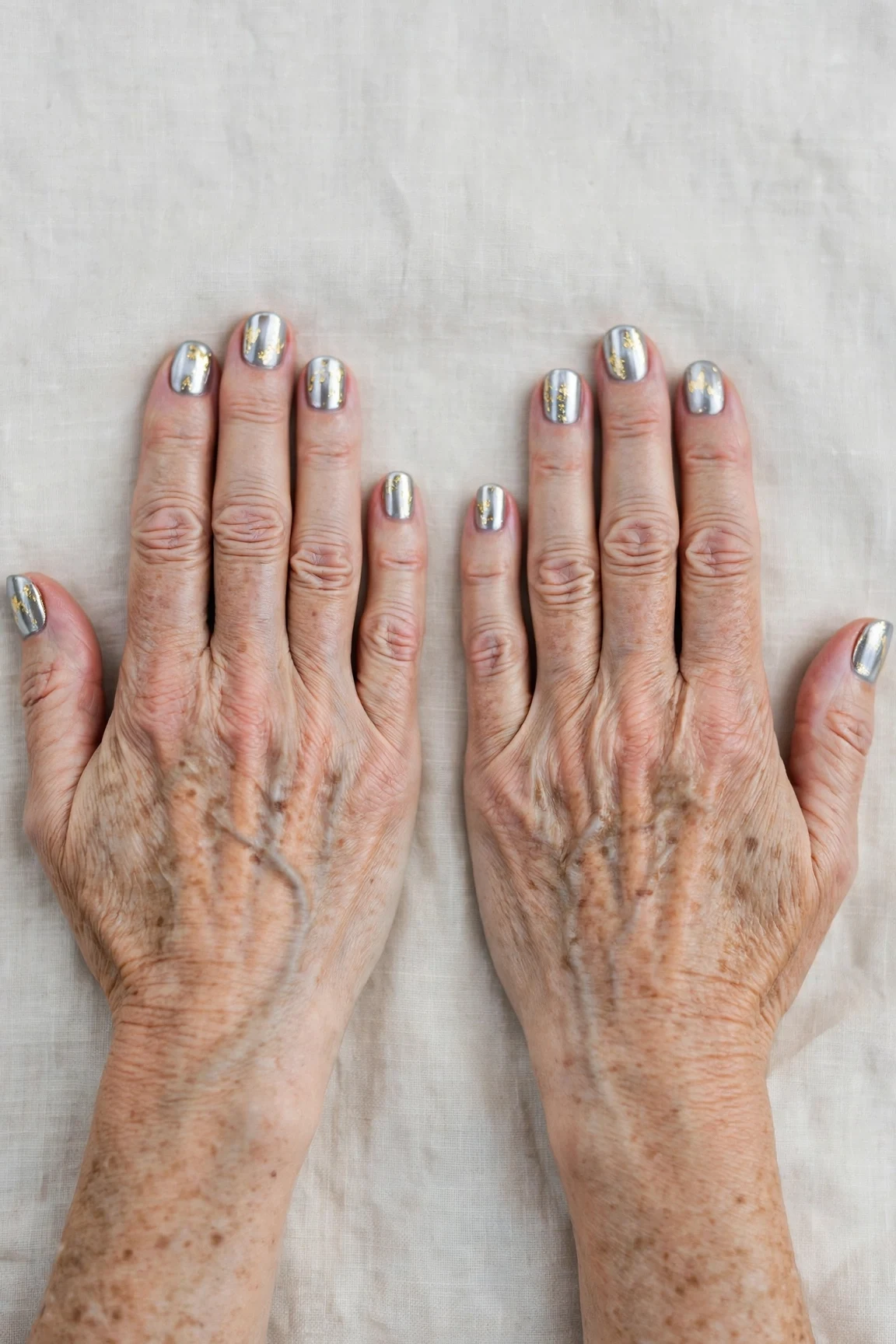 Short Round Icy Silver Frosted Chrome Nails with a deep glossy shine and gold foil accents