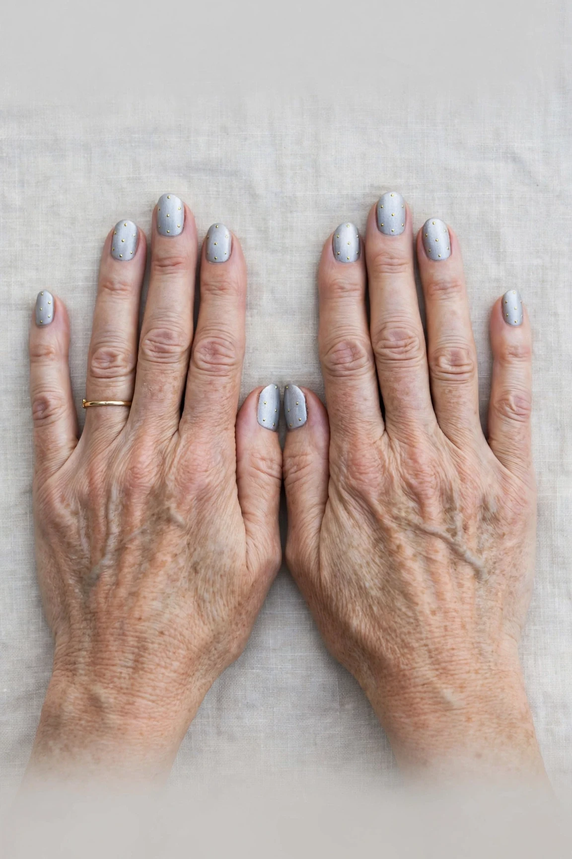 Oval Icy Silver Frosted Chrome Nails with a velvet matte finish and tiny gold dots