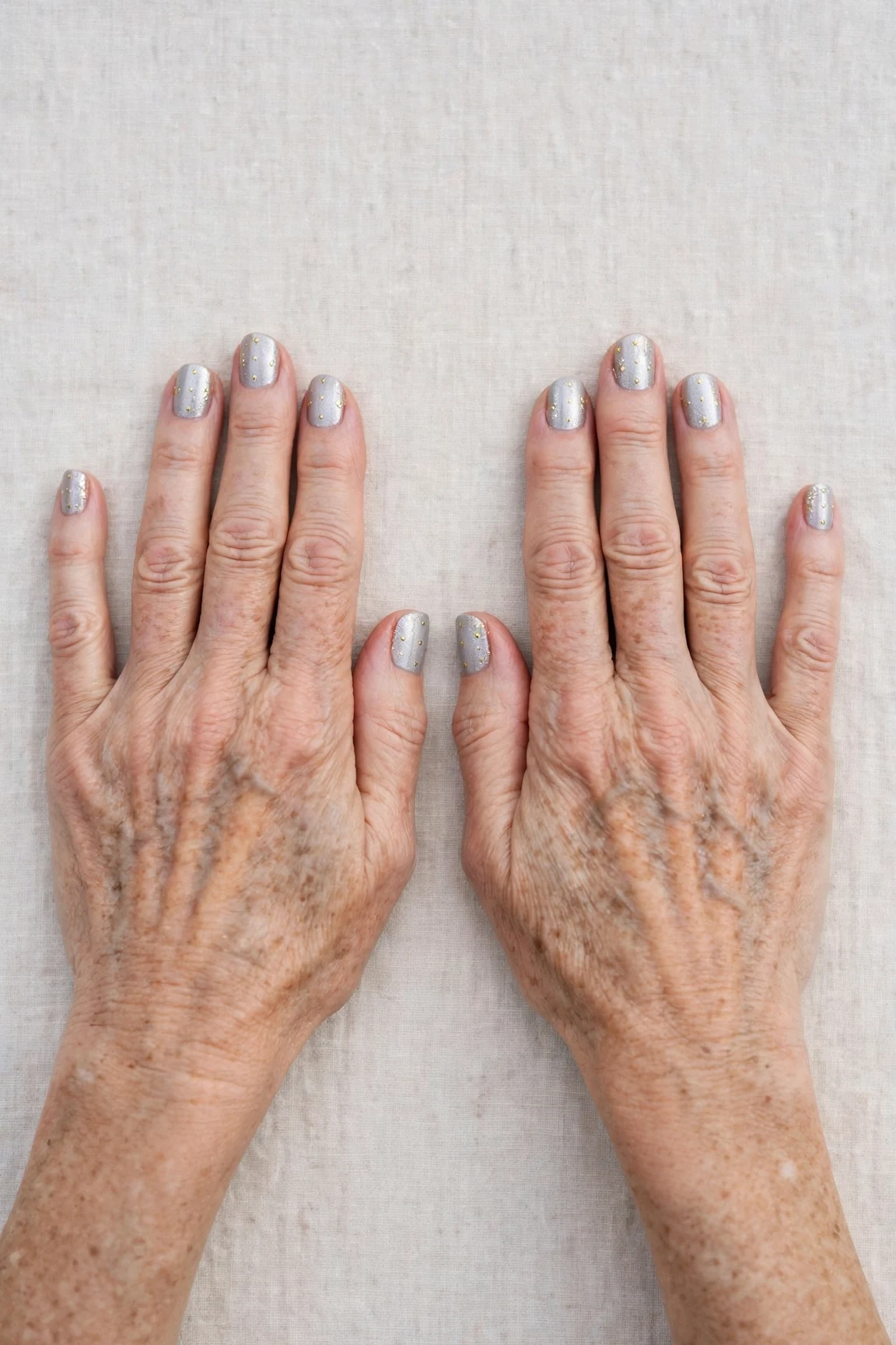 Short Round Icy Silver Frosted Chrome Nails with a frosted shimmer finish and tiny gold dots
