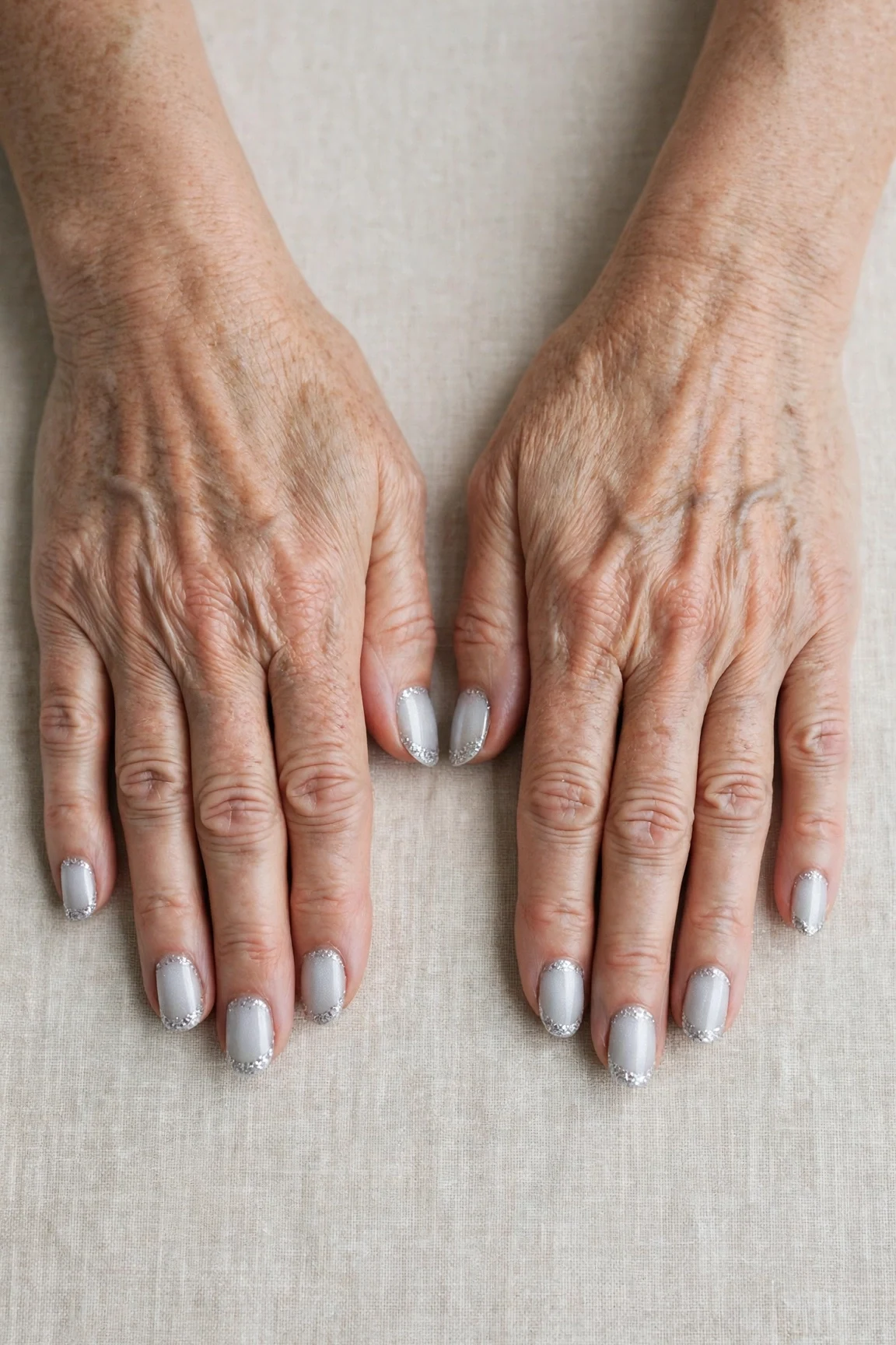 50 Icy Silver Frosted French Nails For Women Over 60 For New Year Celebrations That Are Chic, Warm and Elegant 33 Icy Silver Frosted French Nails with a pearl shimmer finish and glitter French tips
