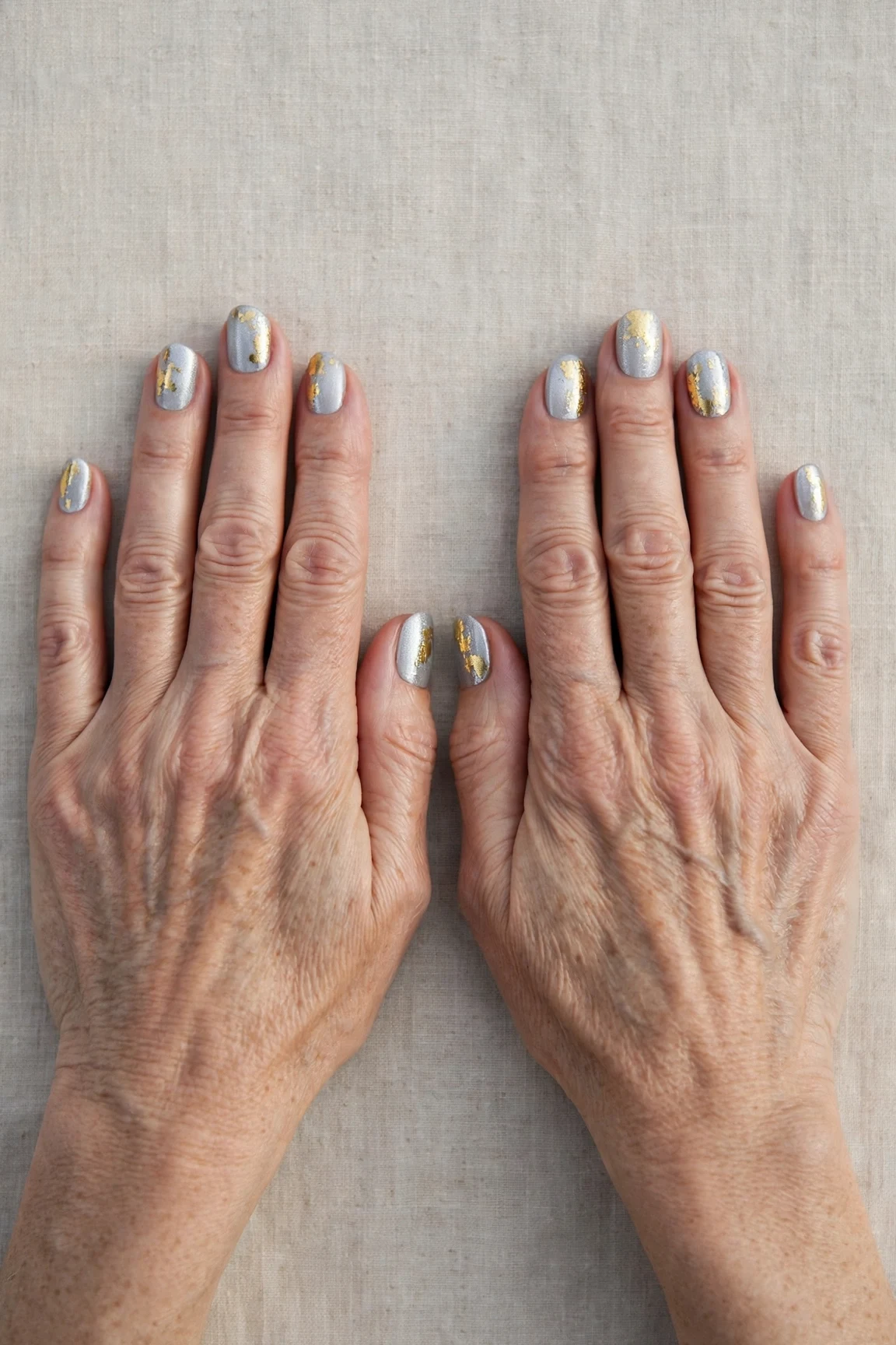 20 Icy Silver Frosted Nail Designs For Women Over 60 For Winter Weddings That Are Chic, Warm and Elegant 2 Short Oval Icy Silver Frosted Nail Designs with a high-gloss finish and gold foil accents