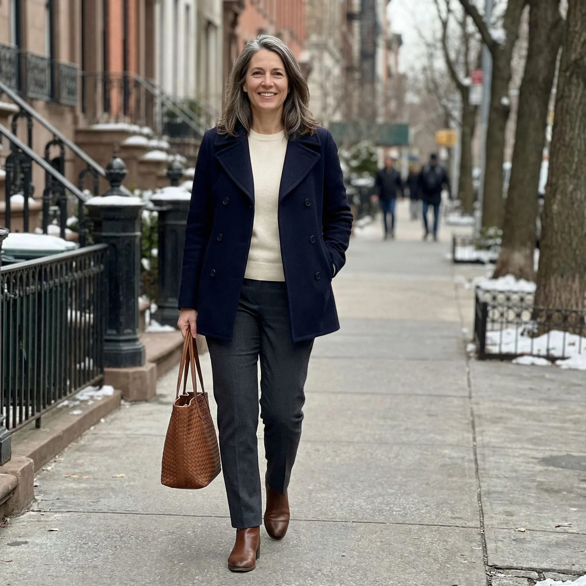 Cream Knit Sweater under a Navy Coat with Charcoal Trousers and Brown Ankle Boots