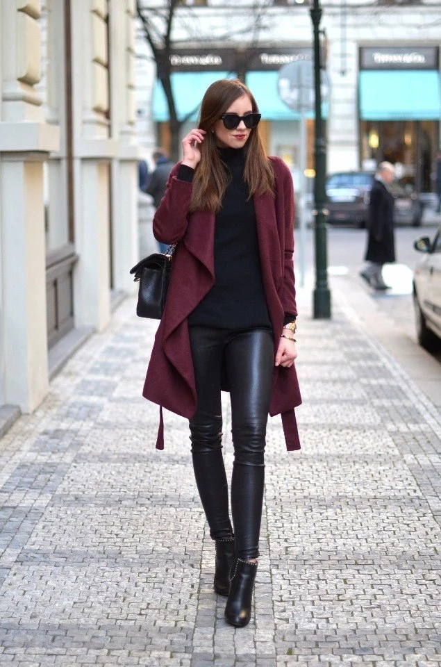 Black Knit Sweater under a Burgundy Coat with Black Leather Trousers and Black Ankle Boots
