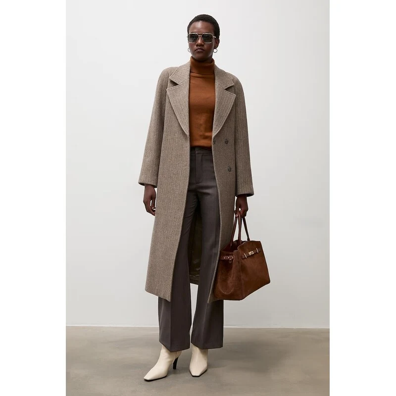 Rust Knit Sweater under a Beige Coat with Charcoal Trousers and Cream Ankle Boots