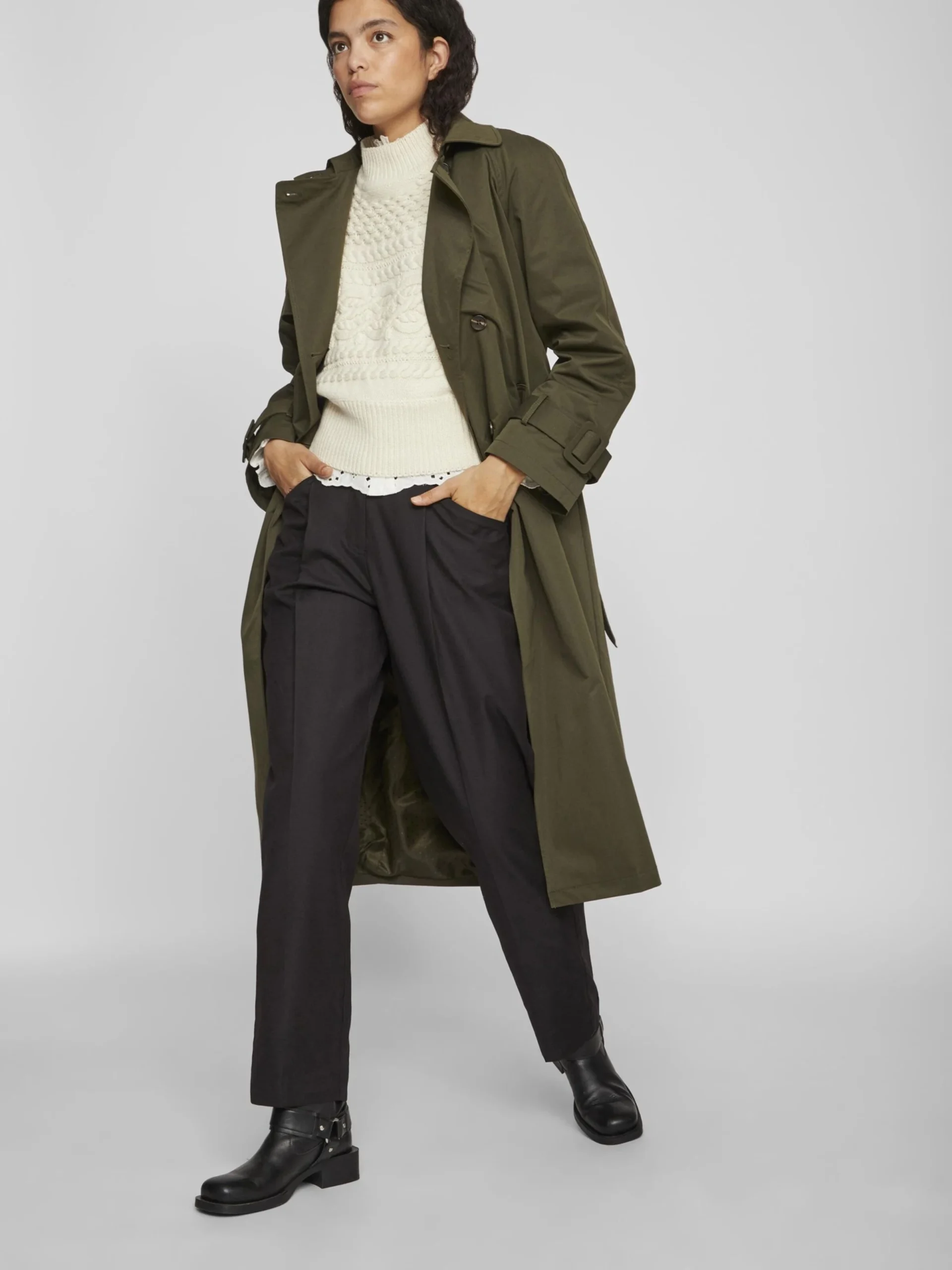 Cream Knit Sweater under a Olive Coat with Black Trousers and Black Ankle Boots
