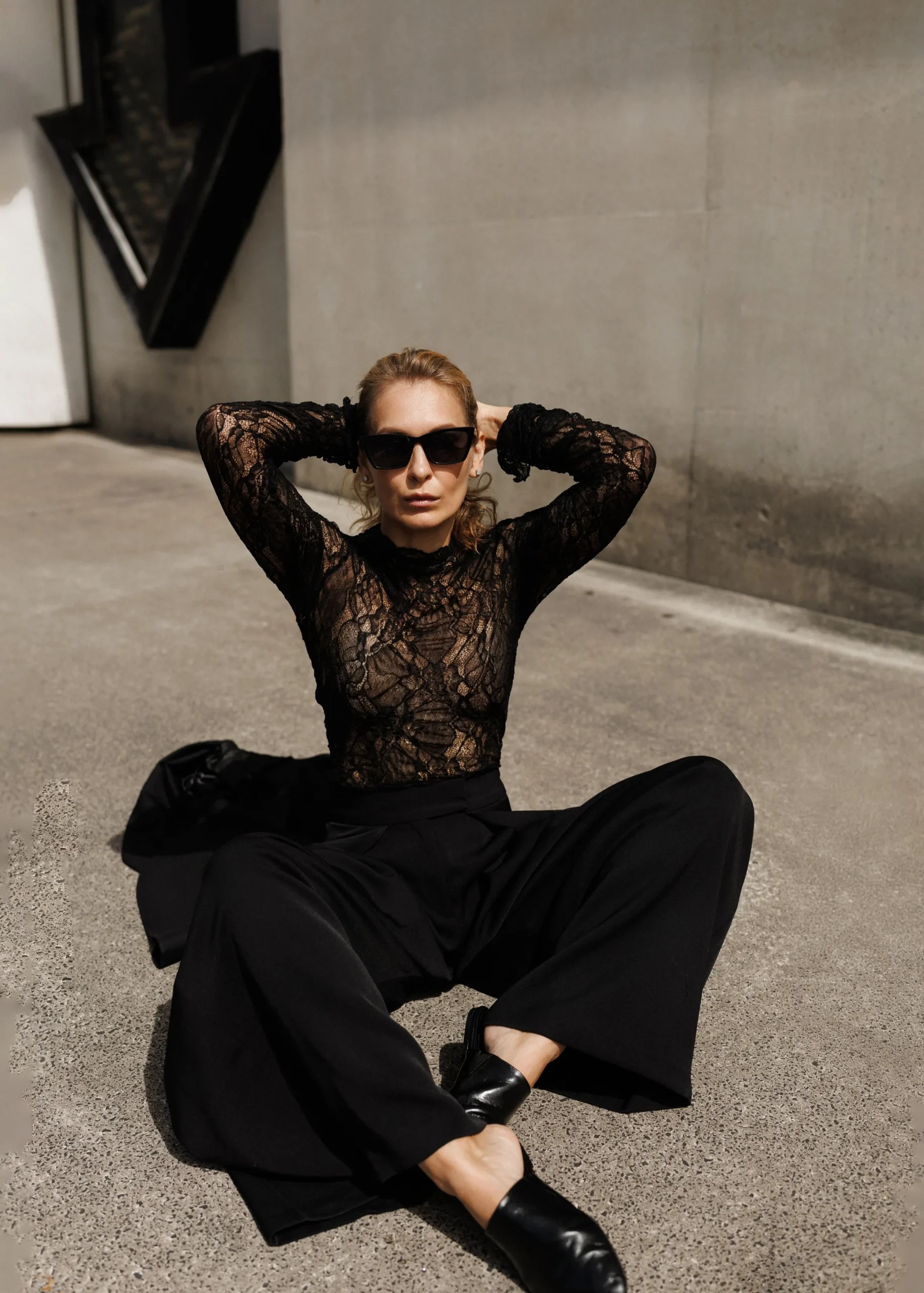 Black lace top and straight trouser outfit with leather ankle boots and statement earrings