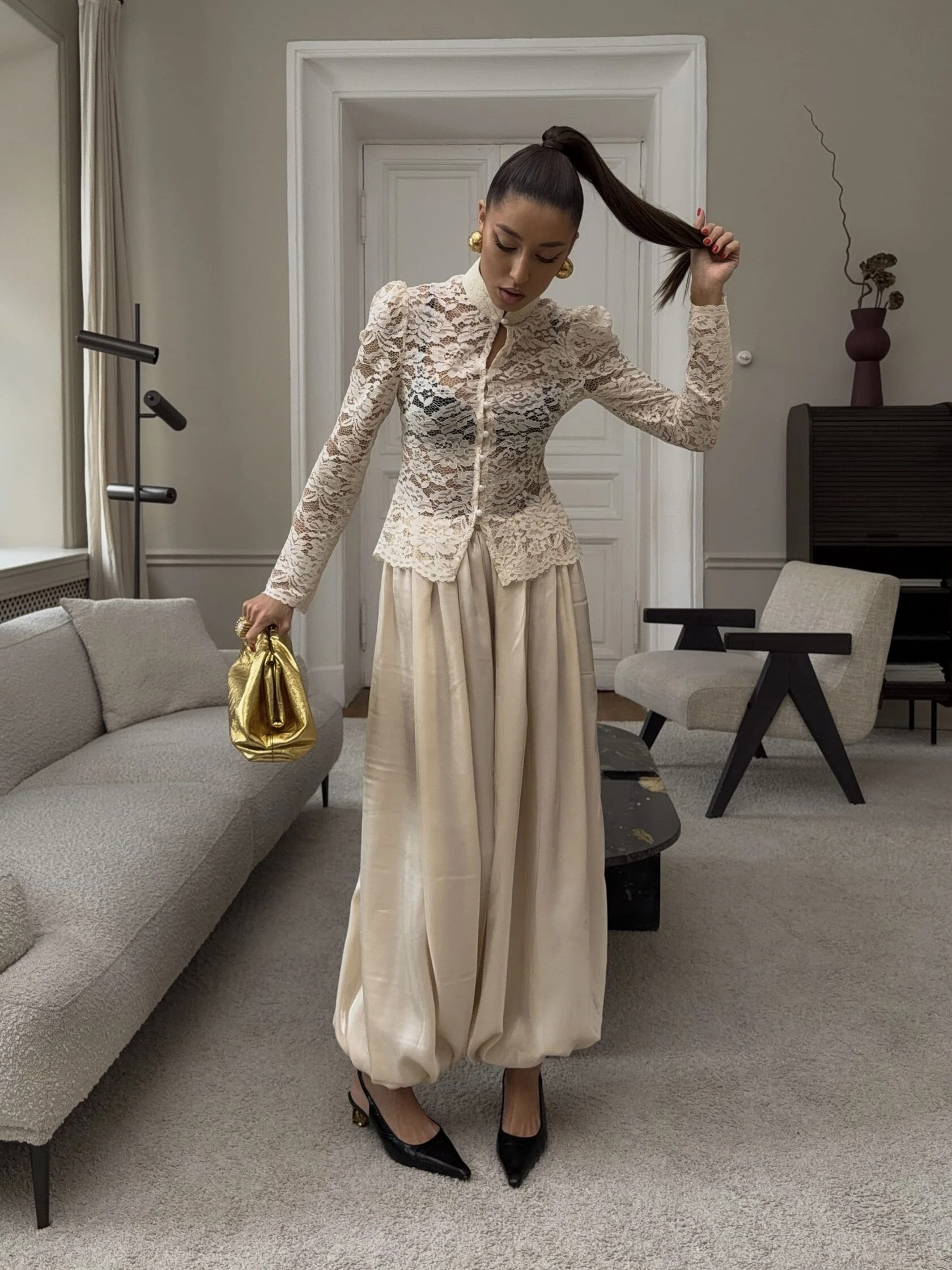 Cream lace top and satin trouser outfit with black pointed heels and statement earrings