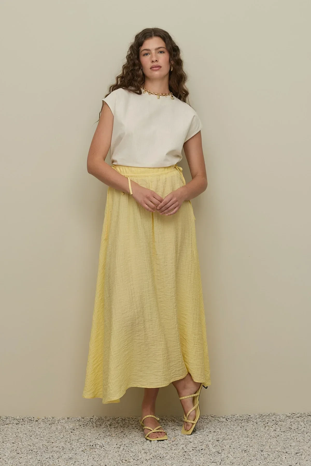 Soft Yellow Midi Skirt with a gold pendant necklace