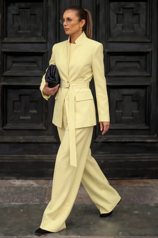 Pale Yellow Tailored Coat with a small black clutch