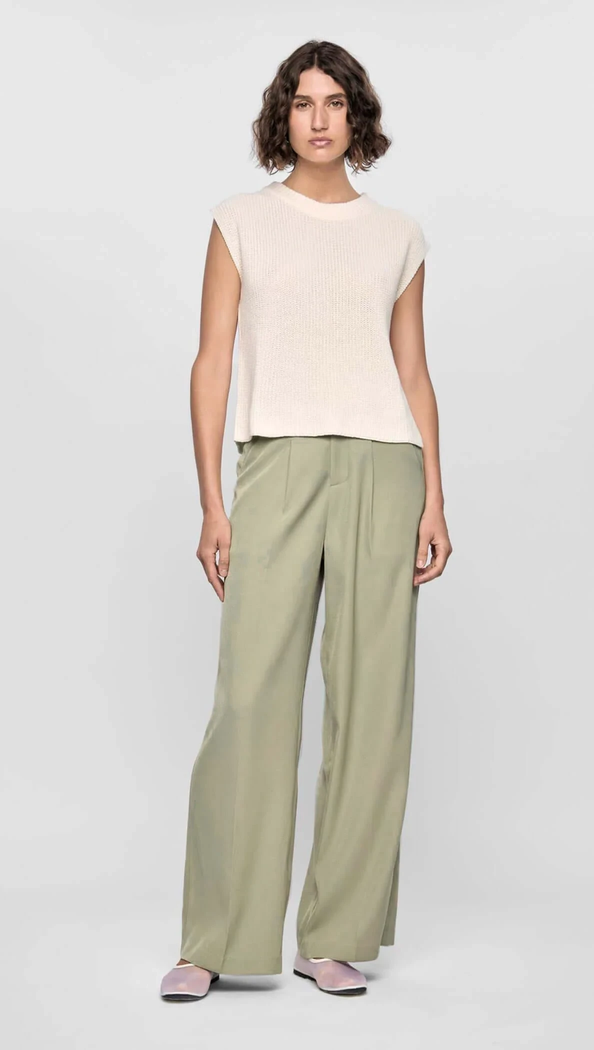 Sage green wide-leg trousers with a cream knit top