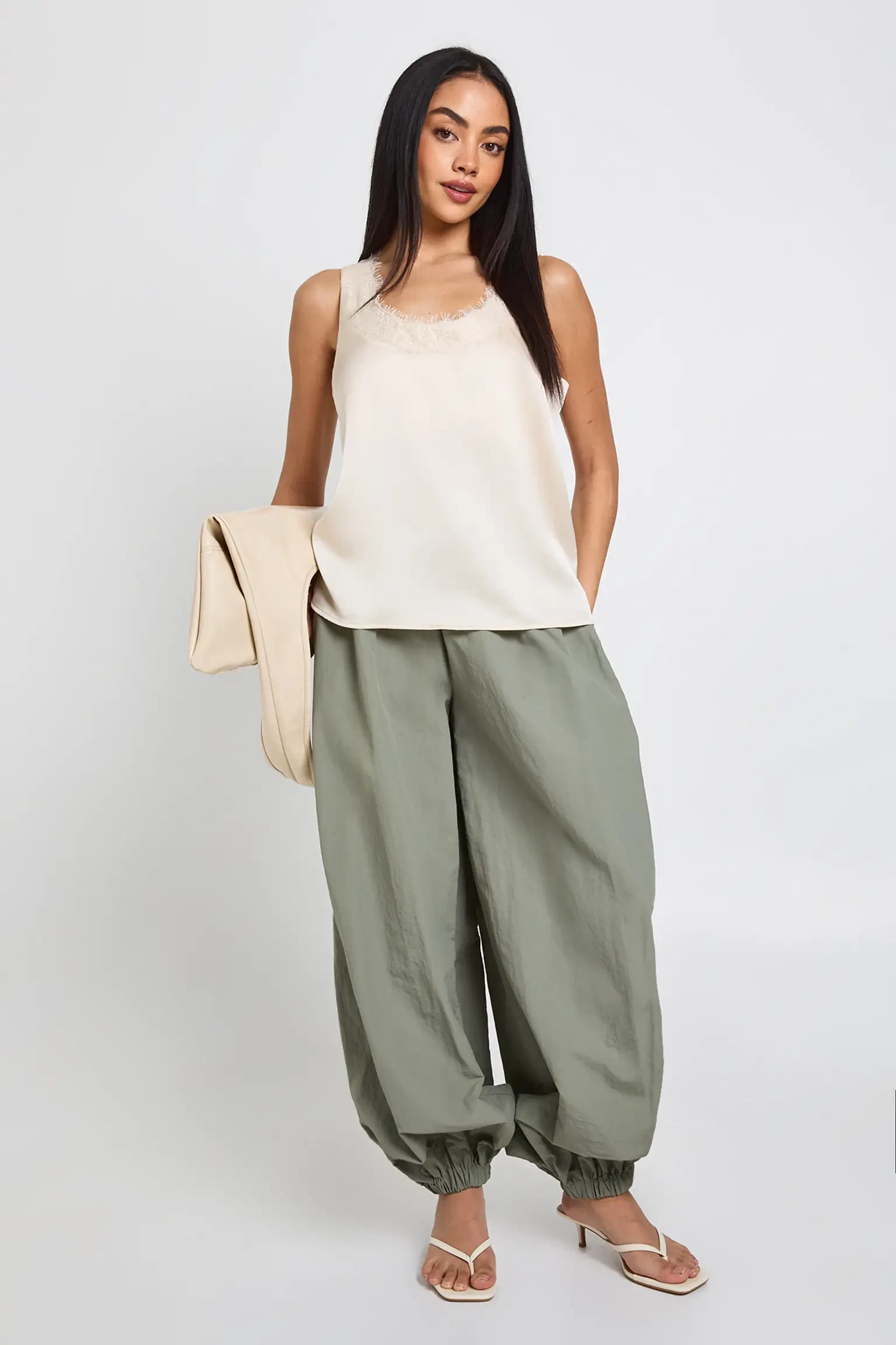 Sage green ankle-length trousers with a cream silk camisole