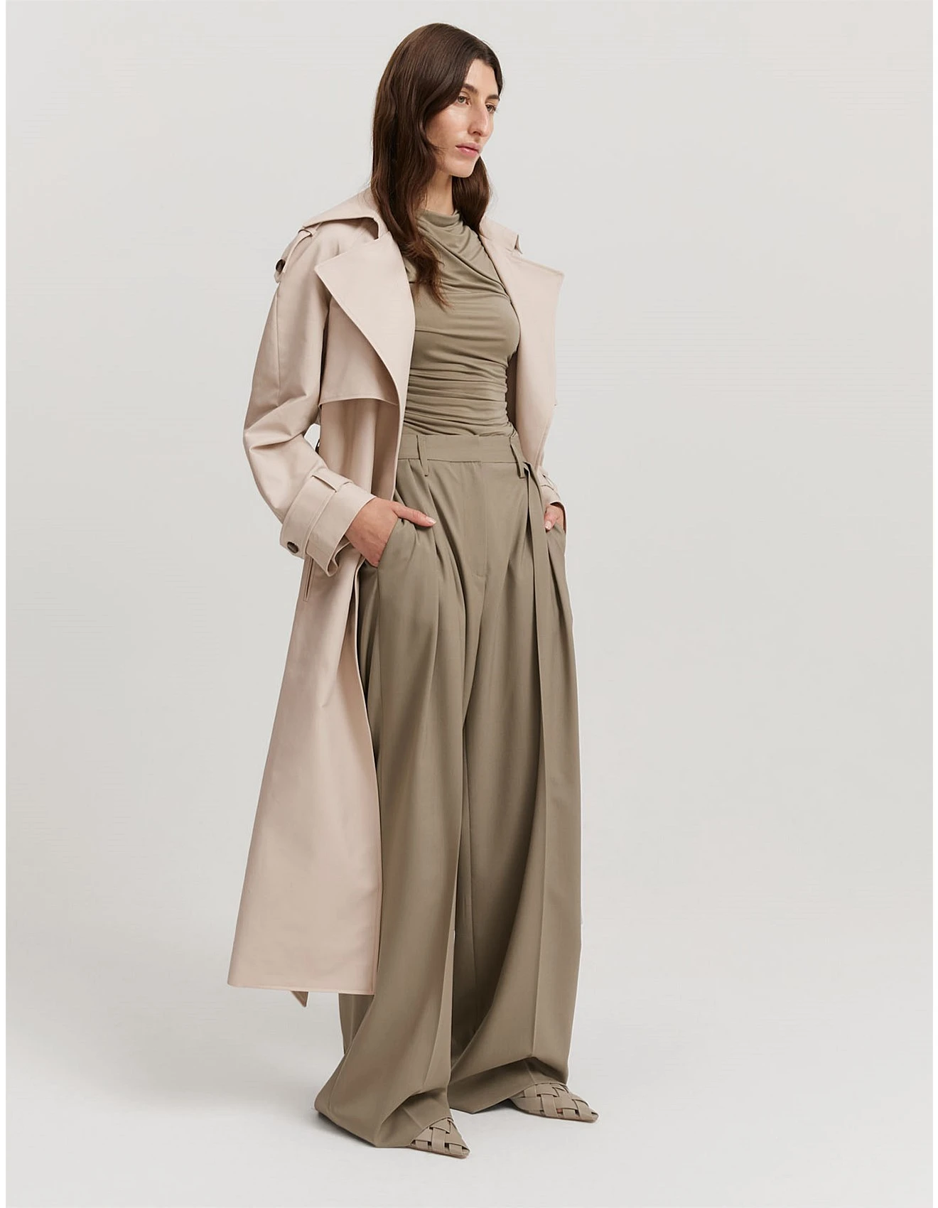 Sage green wide-leg trousers with a beige trench coat