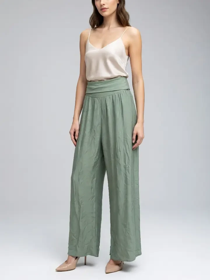 Sage green paperbag-waist trousers with a cream silk camisole