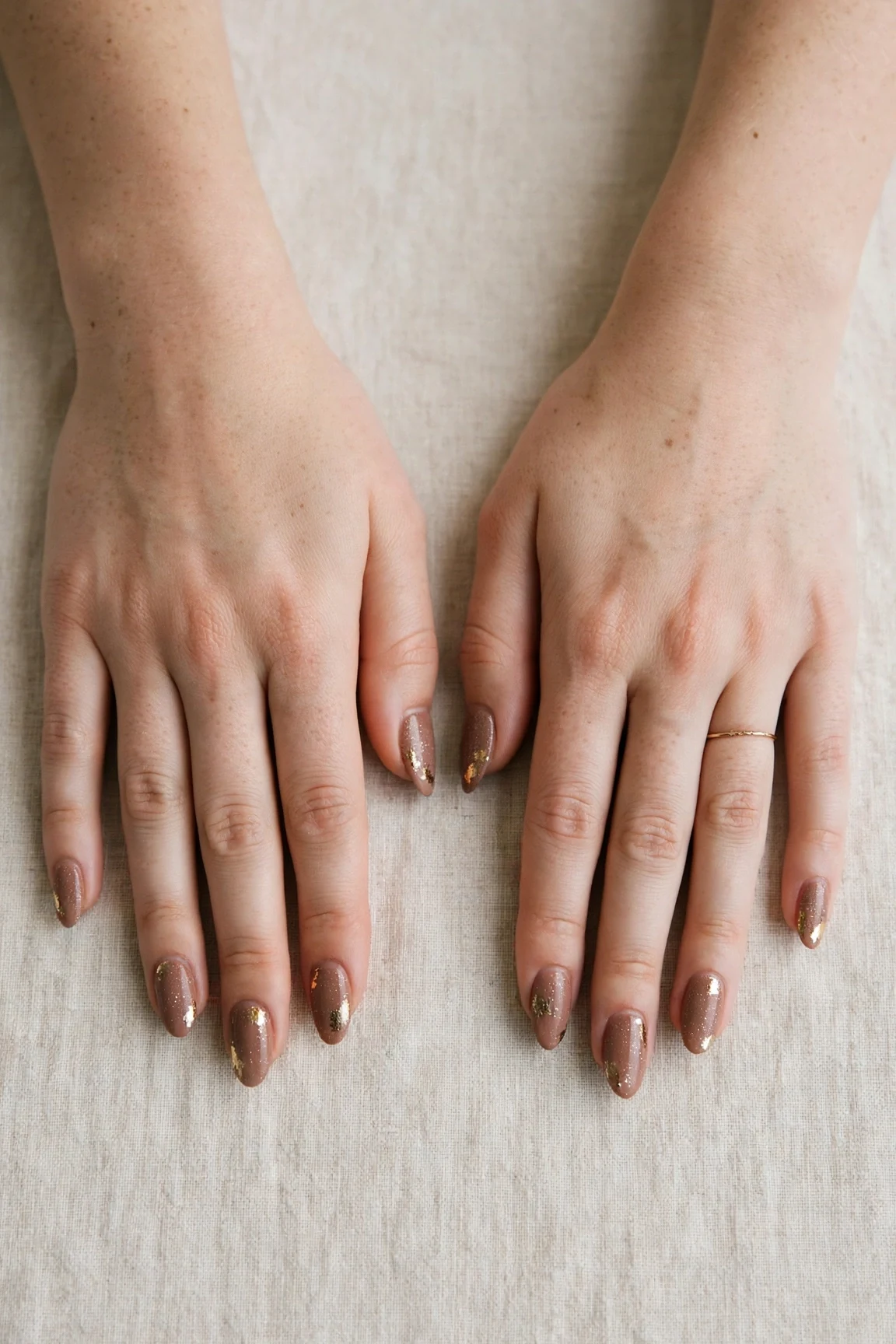 Almond Mocha Brown Glitter Christmas Nails with a soft matte finish and gold foil accents