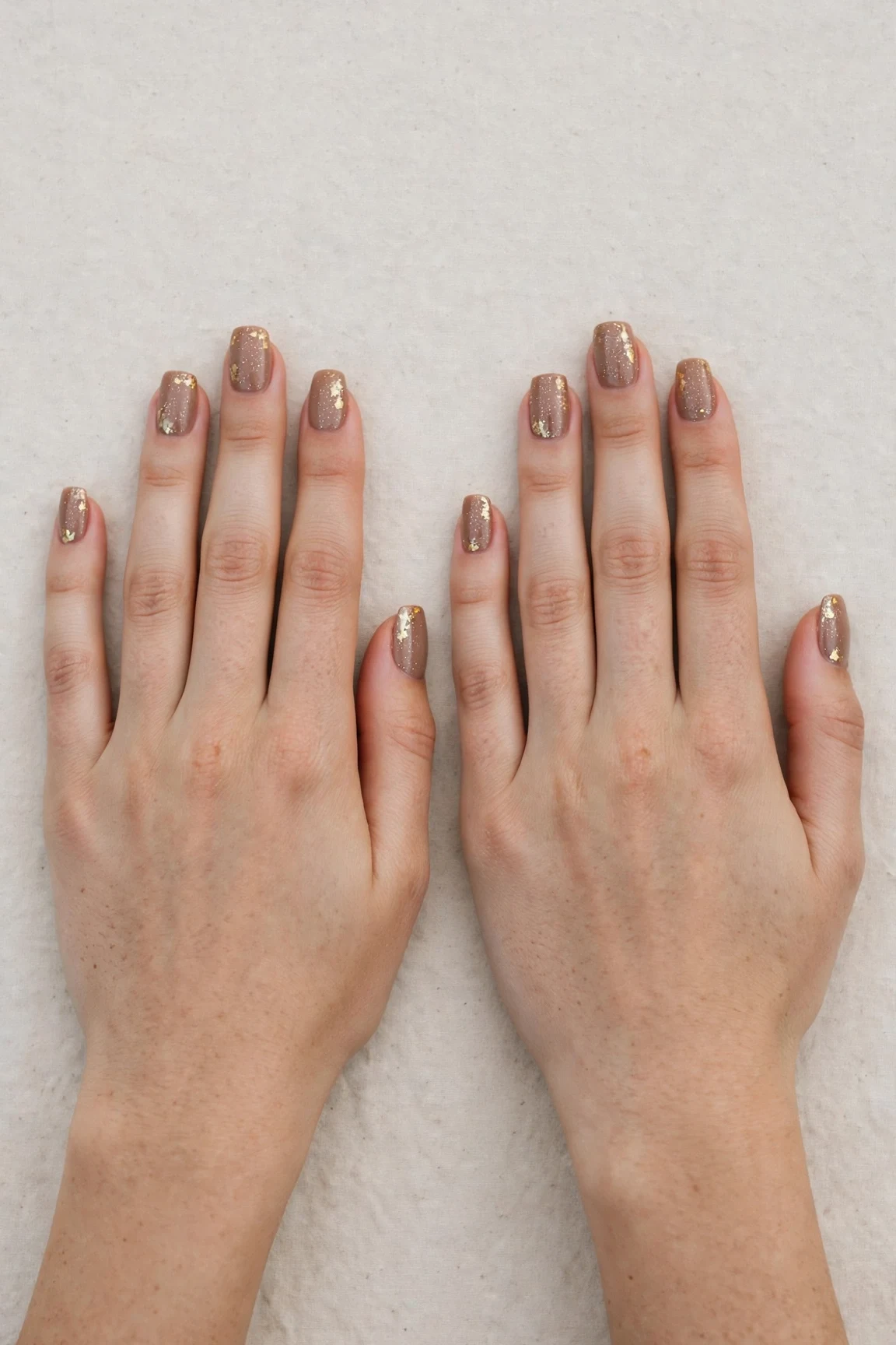 Squoval Mocha Brown Glitter Christmas Nails with a creamy opaque finish and gold foil accents