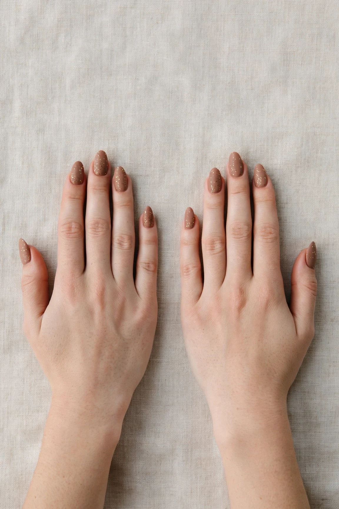 Almond Mocha Brown Glitter Christmas Nails with a soft matte finish and tiny gold dots