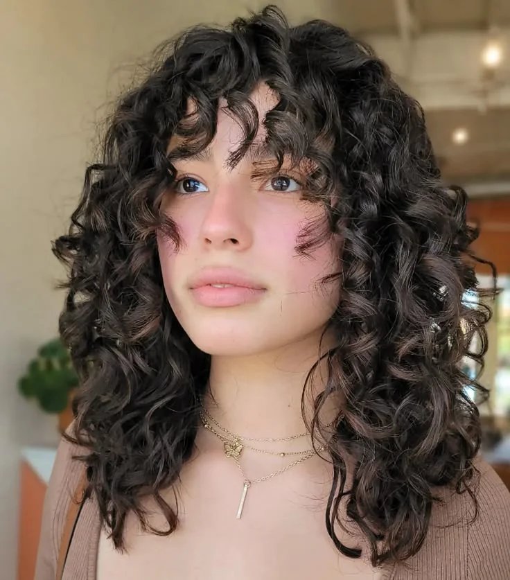 Natural Texture Spring Hairstyles For Curly Hair With Defined Curls With Loose Romantic Curls, A Layered Shape That Moves And A Glossy Shine Finish