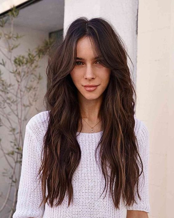 Natural Texture Spring Hairstyles For Wavy Hair With A Salt Spray Finish With Smooth Glossy Lengths, Feathered Ends And Rich Chocolate Depth