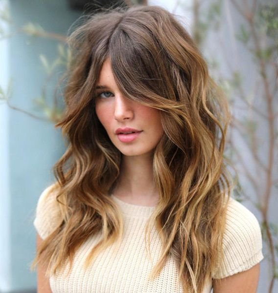 Natural Texture Spring Hairstyles For Wavy Hair With A Salt Spray Finish With Soft Waves, Face-Framing Layers And Warm Caramel Tones