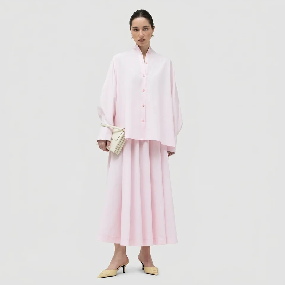 Soft pink A-line skirt outfit with pointed mules and statement earrings
