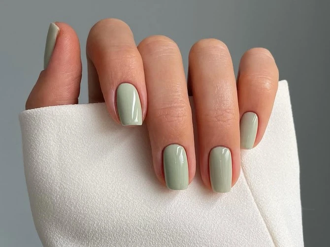 Short Oval Pistachio Green Minimalist Nails with a matte finish and a bare accent nail