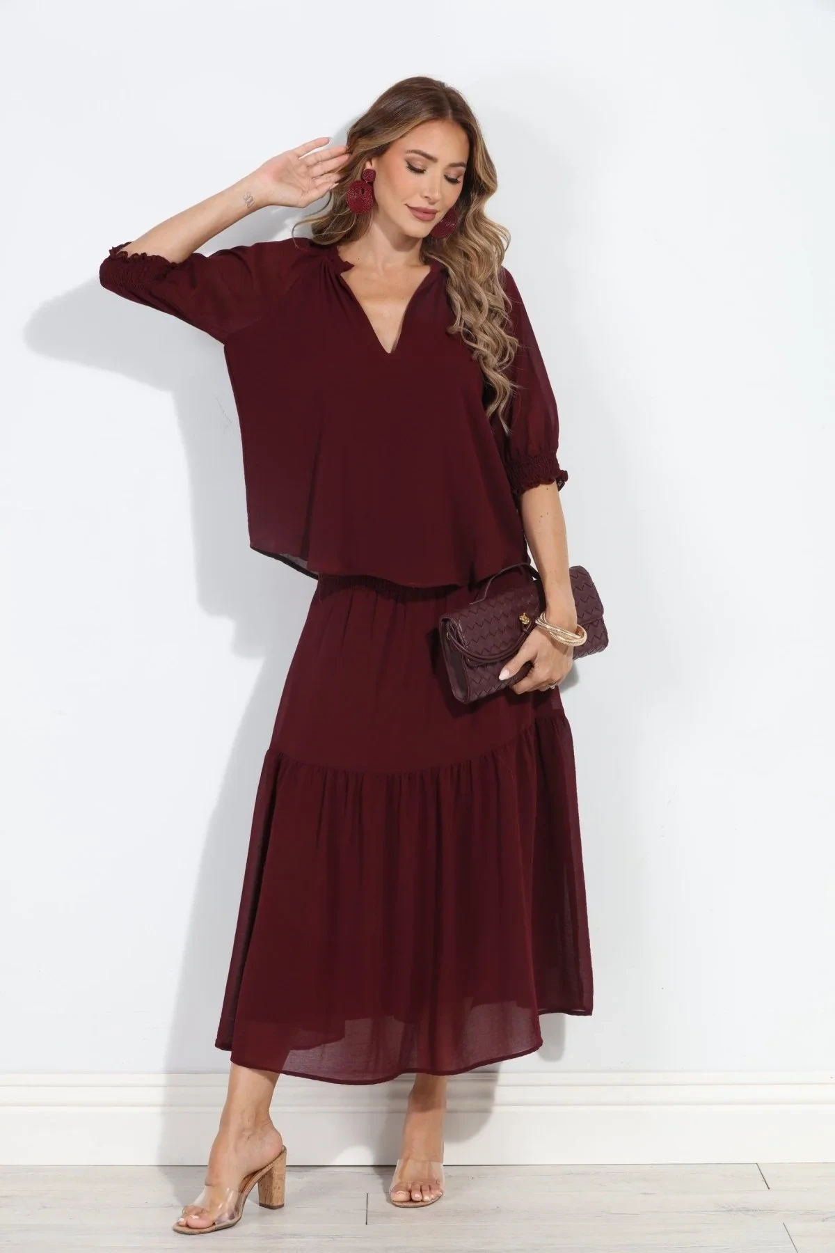 Burgundy blouse and tiered skirt outfit with low-heeled pumps and a chic crossbody bag