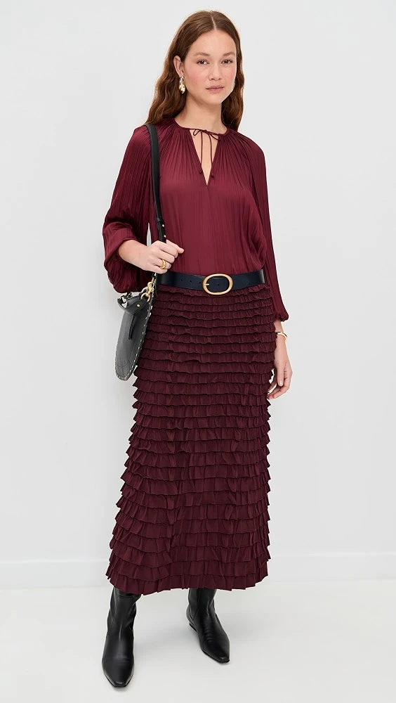 Burgundy blouse and pleated skirt outfit with leather ankle boots and a chic crossbody bag