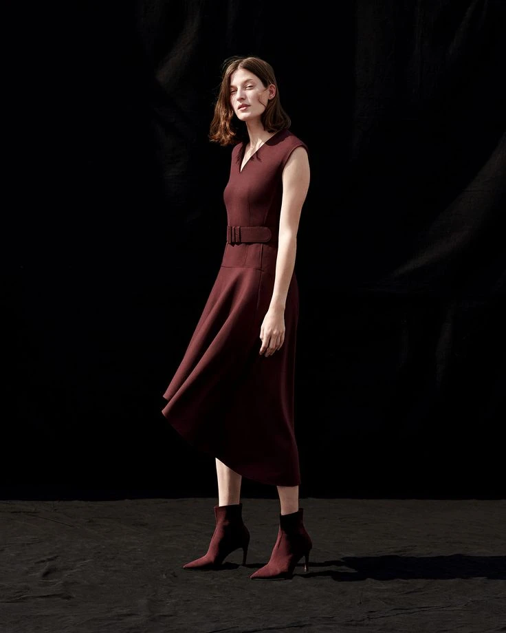 Deep red fit-and-flare midi dress with suede ankle boots and statement earrings