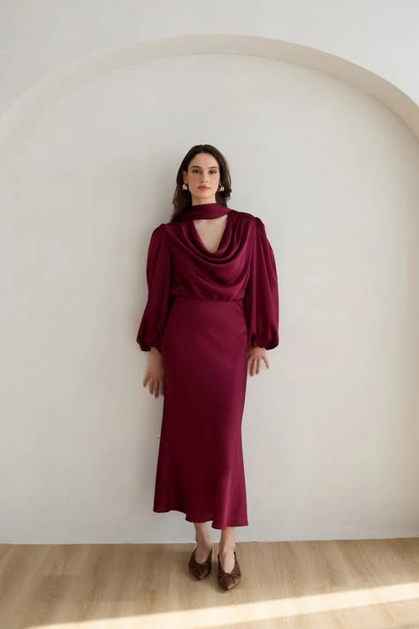Crimson satin long-sleeve dress with elegant pointed flats and a delicate gold necklace