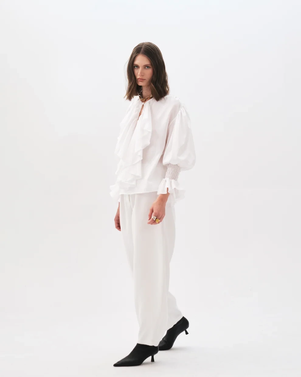 25 Ruffle Blouse Outfits for Valentine Dinners That Are Chic, Romantic and Easy to Wear 13 White ruffle blouse and tailored trouser outfit with leather ankle boots and a delicate gold necklace