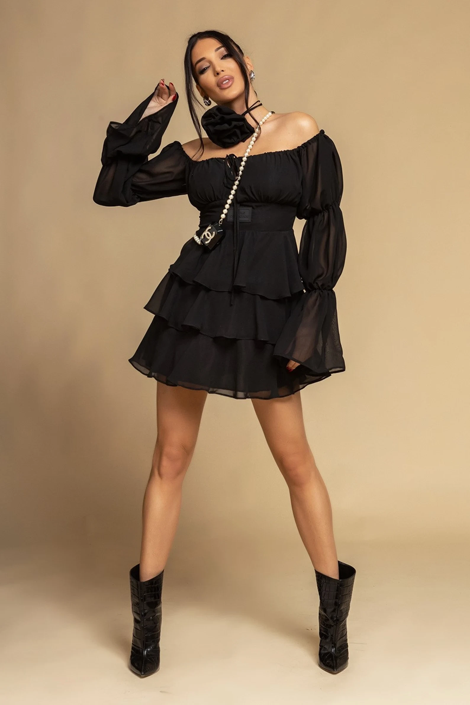 Black ruffle V-neck dress with block-heel ankle boots and a pearl bracelet