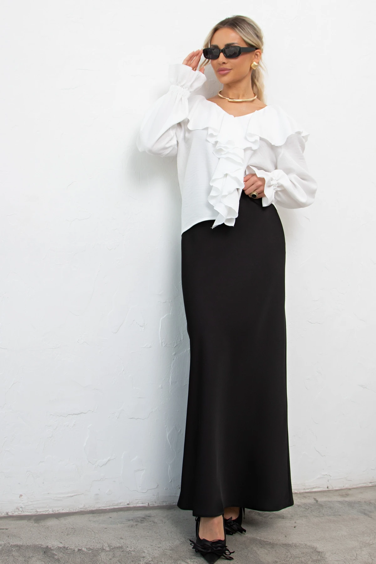 White ruffle sleeve top and skirt outfit with black pointed heels and a delicate gold necklace