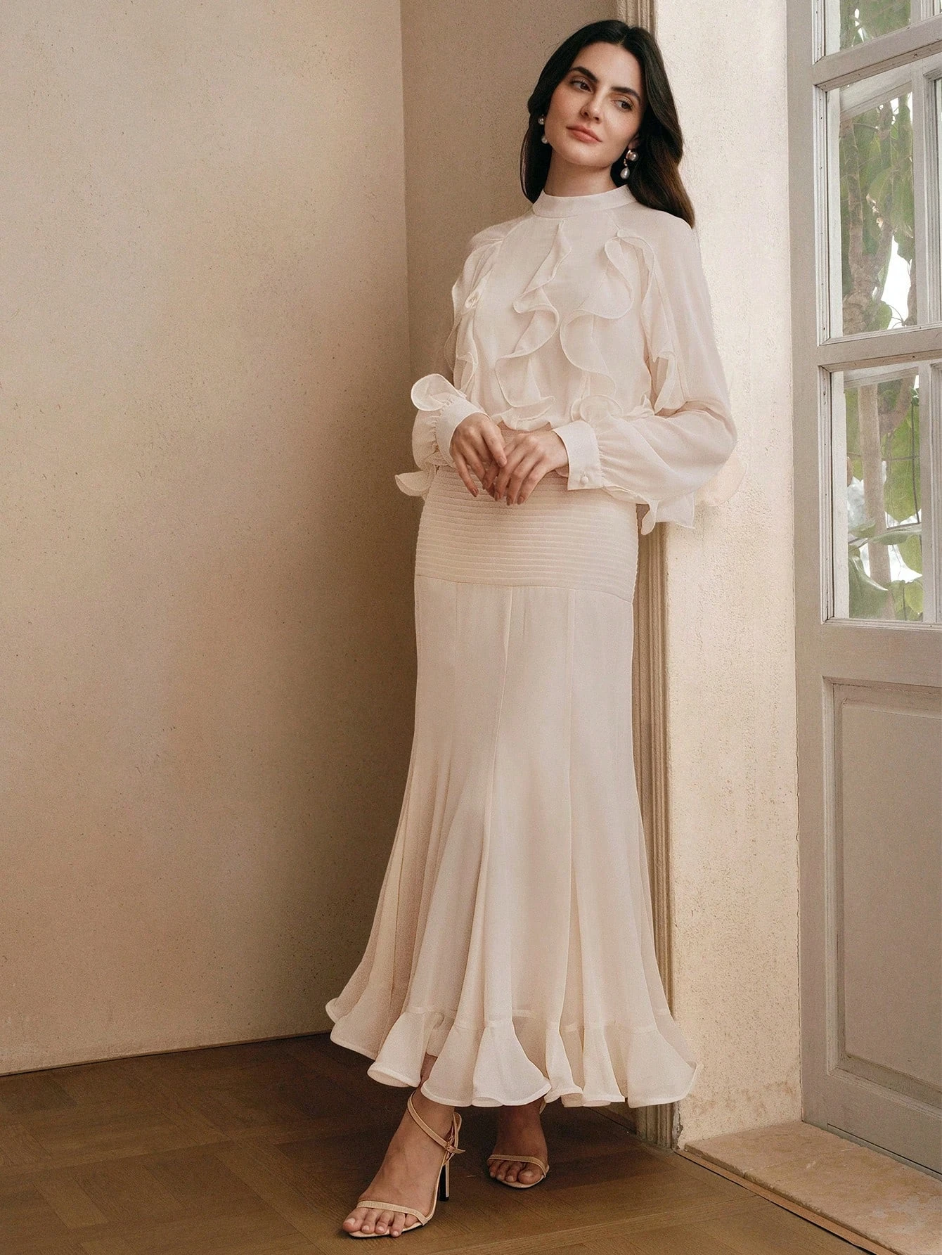 Cream ruffle sleeve top and A-line skirt outfit with low-heeled pumps and a pearl bracelet