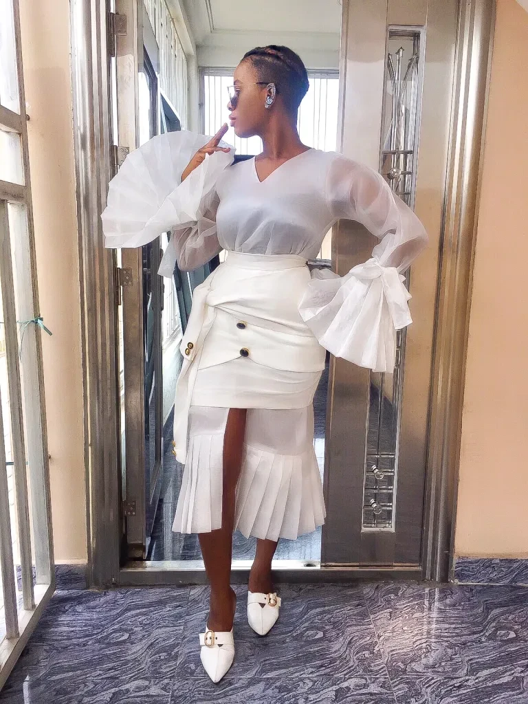 White ruffle sleeve top and wrap skirt outfit with pointed mules and silver drop earrings
