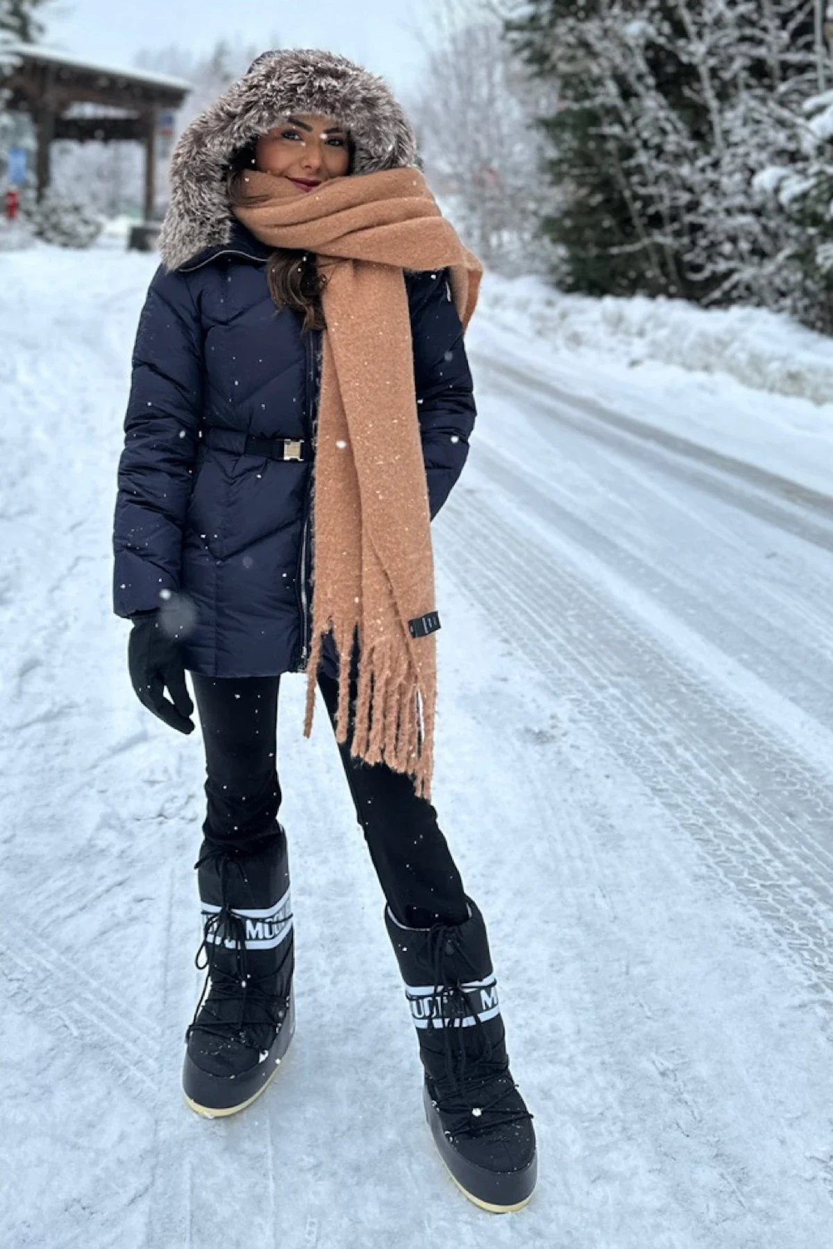 30 Scarf and Coat Layering Outfits for Snowy Walks That Are Chic, Warm and Elegant 6 Navy Coat with a Camel Chunky Scarf with Black Leggings and Black Snow Boots