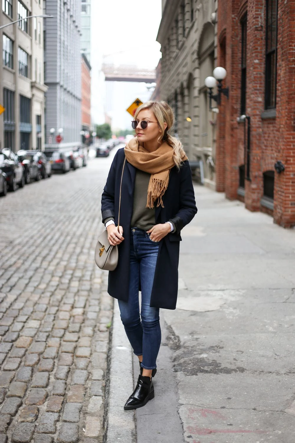 30 Scarf and Coat Layering Outfits for Snowy Walks That Are Chic, Warm and Elegant 8 Navy Coat with a Camel Chunky Scarf with Blue Jeans and Black Ankle Boots