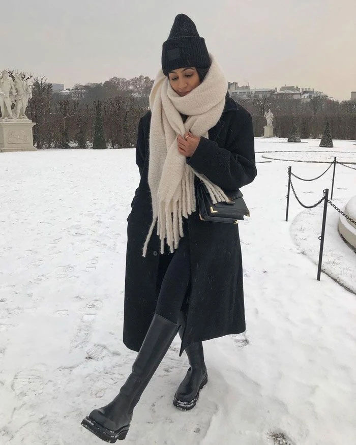 30 Scarf and Coat Layering Outfits for Snowy Walks That Are Chic, Warm and Elegant 31 Black Wool Coat with a Cream Chunky Knit Scarf with Dark Jeans and Black Knee-high Boots