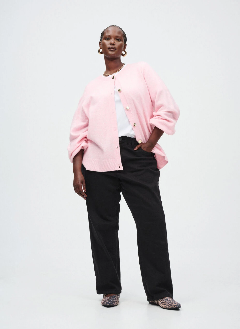 Blush soft pink knit cardigan outfit with black trousers, elegant pointed flats and statement earrings